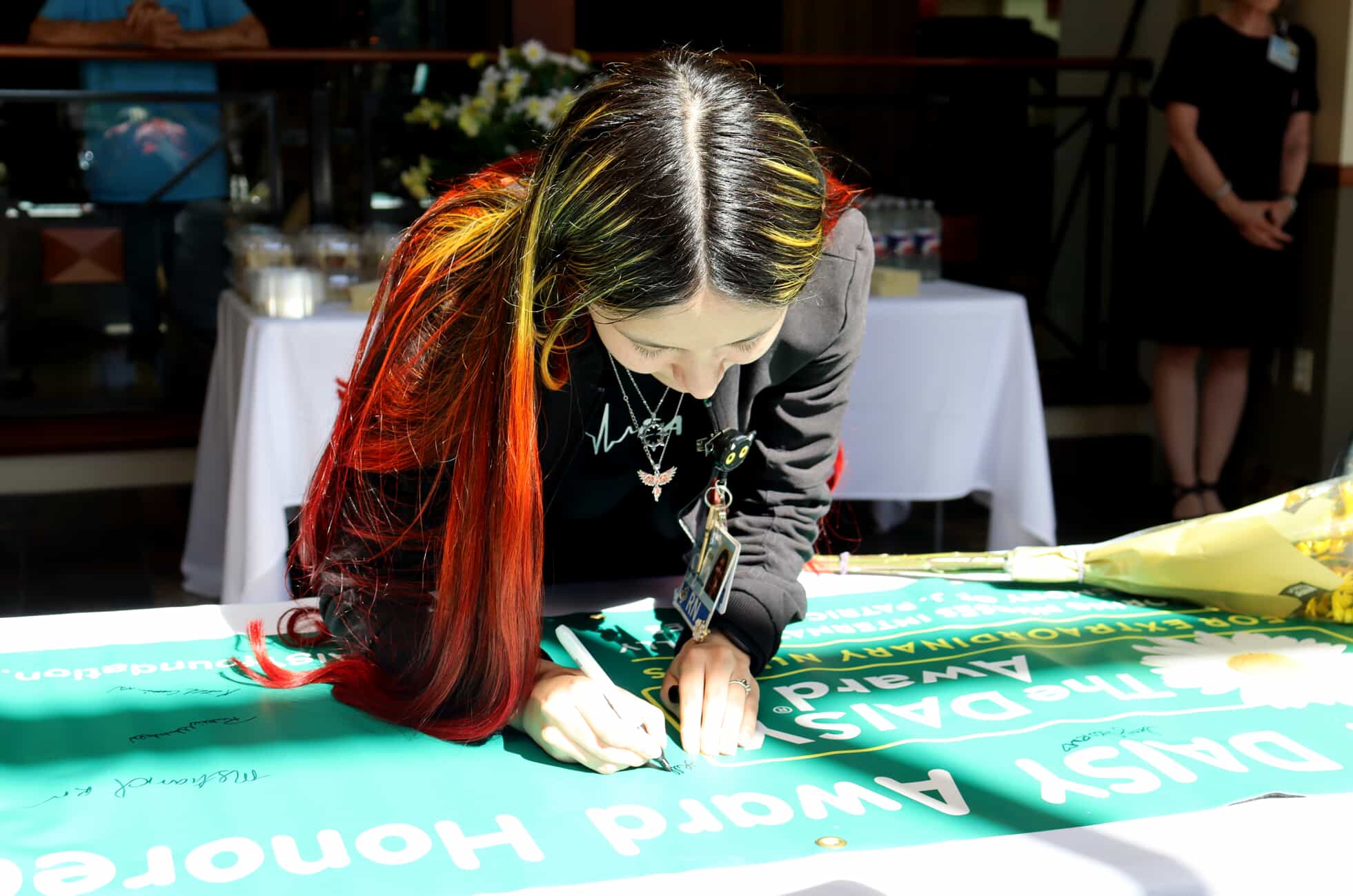 Lilliana signs the DAISY Award banner. 
