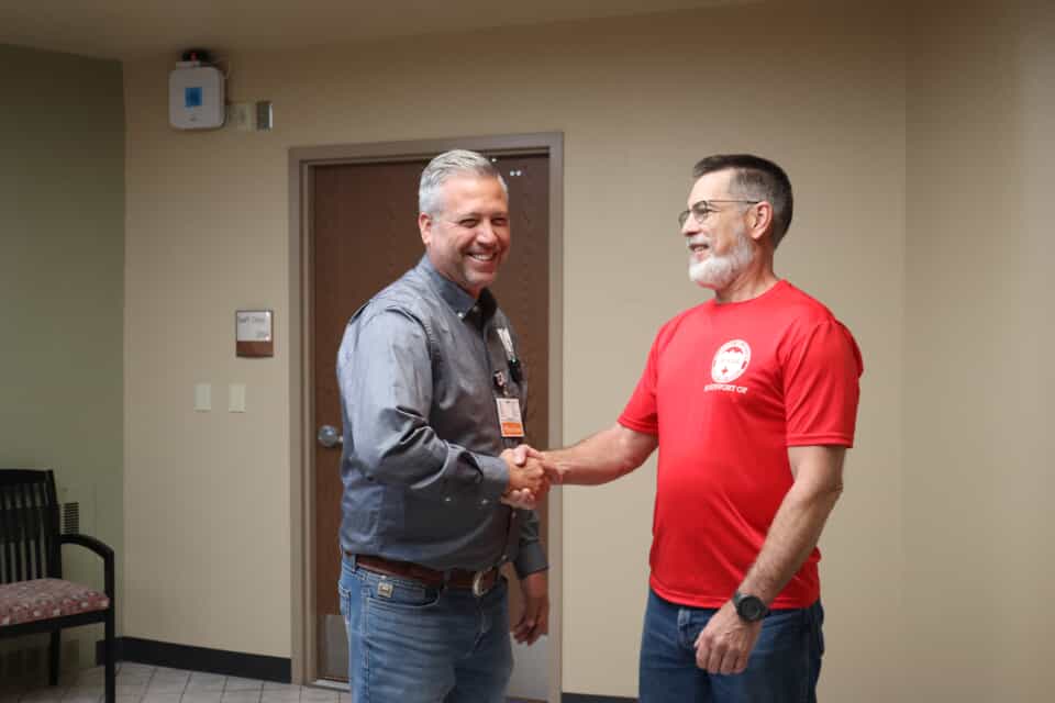 Dr. Clint Sowards Shaking hands with Chris Hendricks