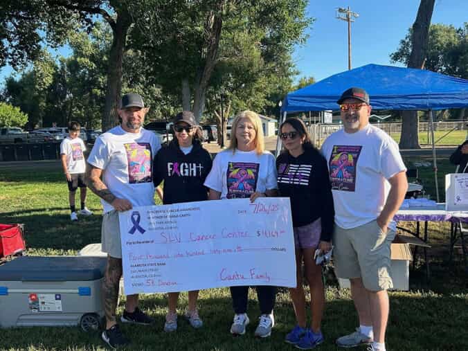 The Cantu family poses with a large check for the SLV Cancer Center. 