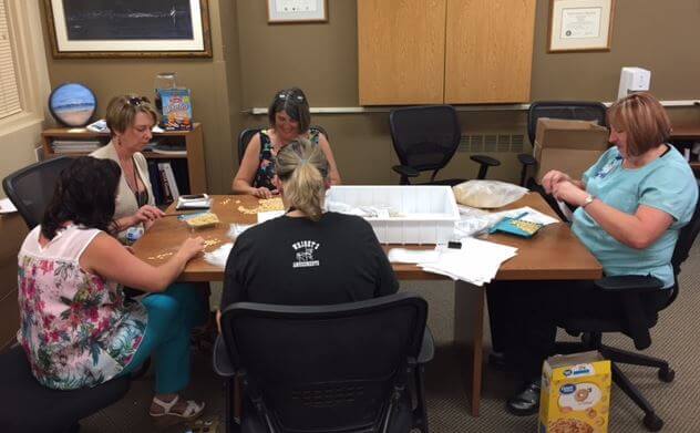 participants sit at table making supplies