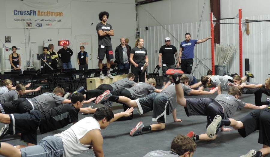 CrossFit staff watch members perform exercise moves