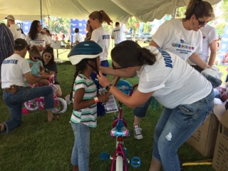 Woman helping child with bike helmet 